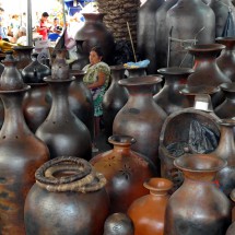 Lady surrounded by huge pots in the market of Uruapan